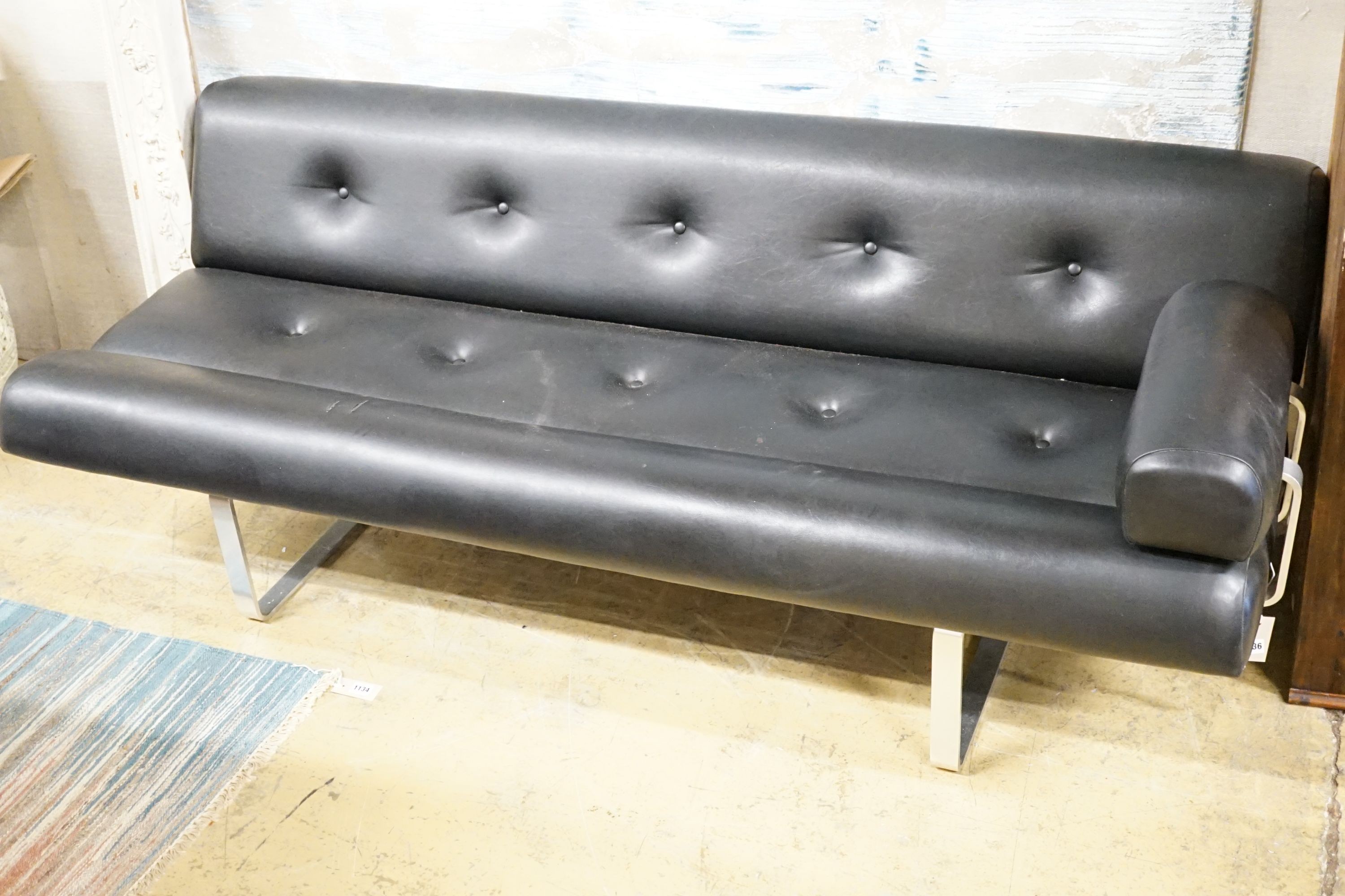 A stylish black vinyl and chrome buttoned settee, by William Plunkett sofa from early 1960s, length 183cm, label on the frame